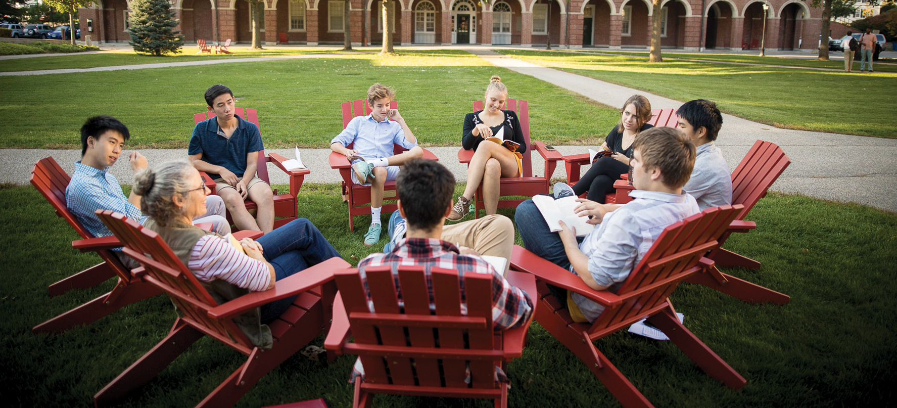 Phillips Exeter Academy students sitting in Adirondack chairs on the quad.