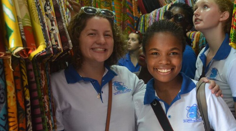 Exeter students smiling at a clothing market in Ghana