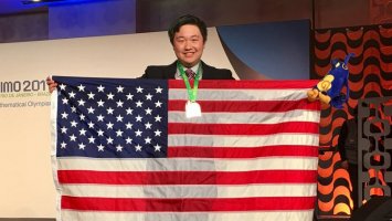 Exeter graduate James Lin a member of the winning team at the 59th International Mathematical Olympiad holding a US flag