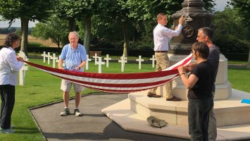 Exeter alumni help fold the American flag in the Aisne-Marne American Cemetery.