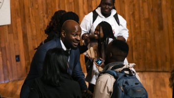 Alex Okosi '94 greets students after delivering his assembly remarks.