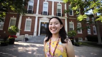 Exeter student Angela Zhang  in the front of the Academy Building 
